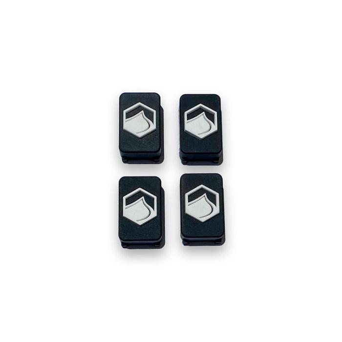 Top View of Four black and white 4D FlexTrack Plugs, part of a hardware set for Liquid Force FlexTrack Wakeboards, on a white background.